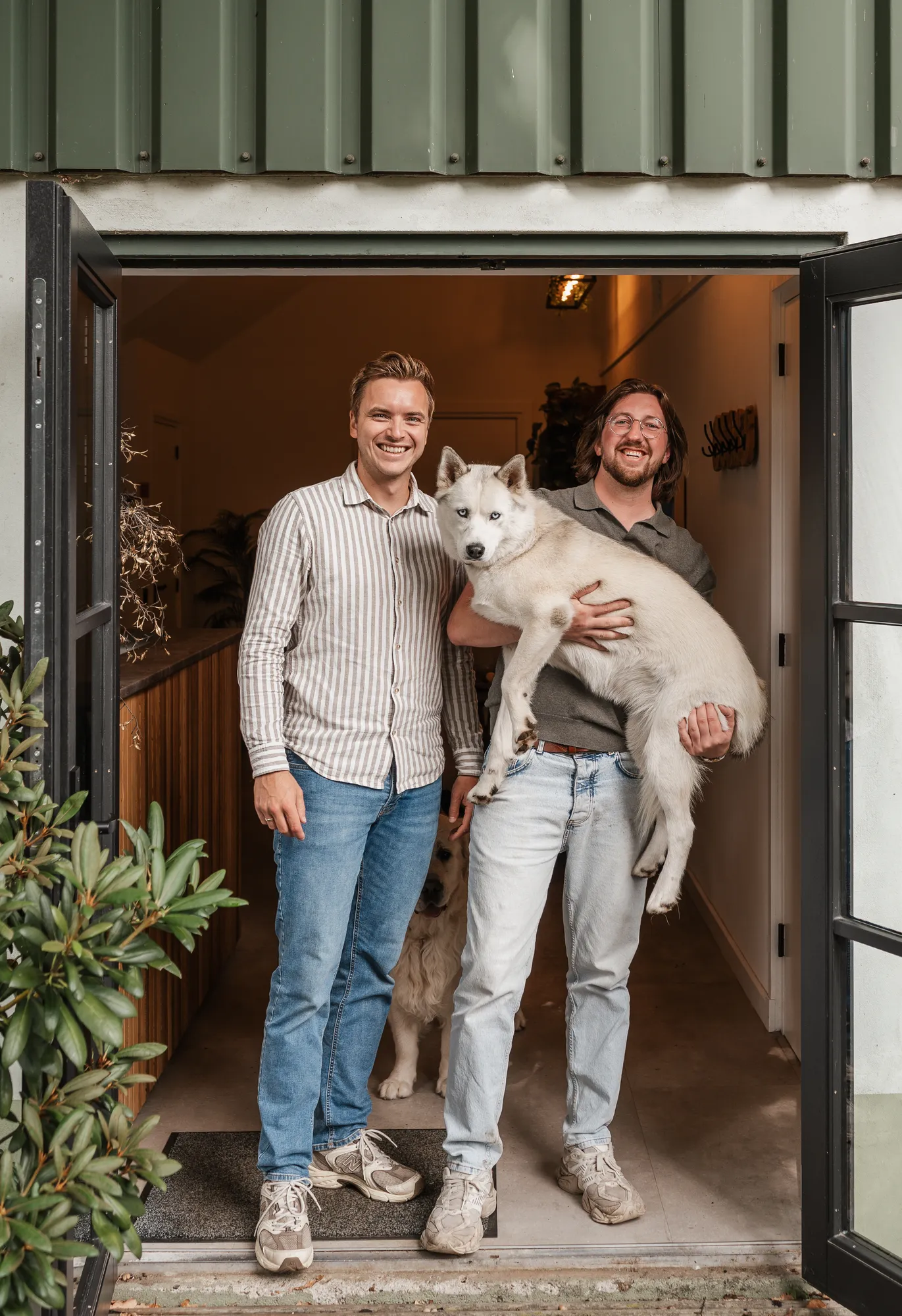 Gerwin en Pascal met husky Raki in de deuropening van het kantoor van Next Win in Otterlo